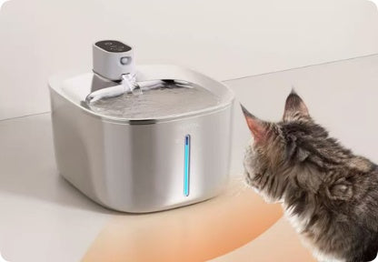 UnpluggedPaws wireless stainless steel pet water fountain with a cat approaching the motion sensor and water flowing into the bowl.